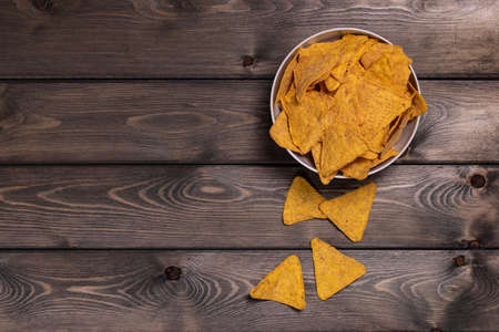 Nachos, corn chips on a deep white plate. Wooden background. The view from the top.の写真素材