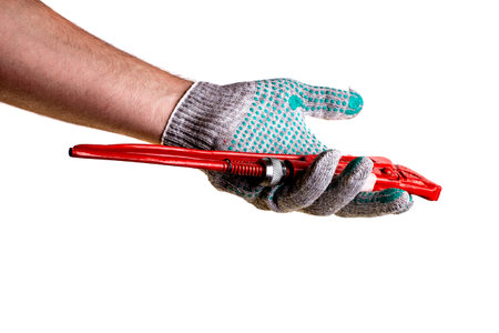 Red adjustable pipe wrench with in hand in knitted protective household glove isolated on white backgroundの写真素材
