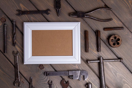 photo frame on wooden background with working toolの写真素材