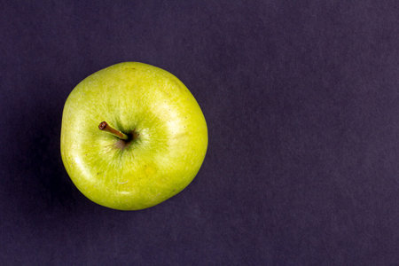 Top view of a fresh green apple against a black textured surface. Copy spaceの写真素材