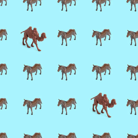 Seamless pattern photo of a toy horse and camel on a blue background creative illustration.