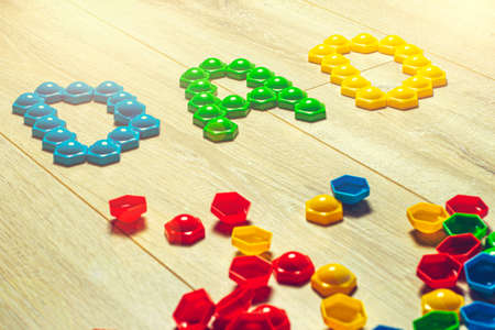 On the floor of a multi-colored mosaic, the child has laid out the word Dad.の写真素材