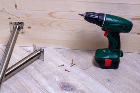Metal legs for mounting on a table and a screwdriver. Furniture accessories. selected focus