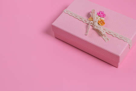 Top view of a pink gift box with a vintage ribbon on a pink background and a copy space. Promotion of sales of business and financial purchases.の写真素材