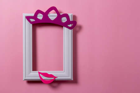 Blank photo frame template for placing an image or text inside on a pastel pink wall. Frame with decor.の写真素材