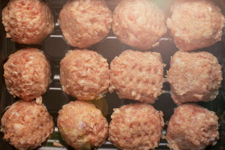 prepared raw meat balls in a black special tray. the selected focus.