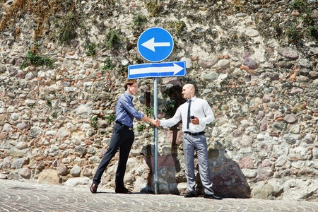 Two buisnessmans meet each other from different directions and shaking thair hand according somethingの写真素材