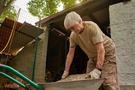 Senior man working in retirement in the gardenの写真素材