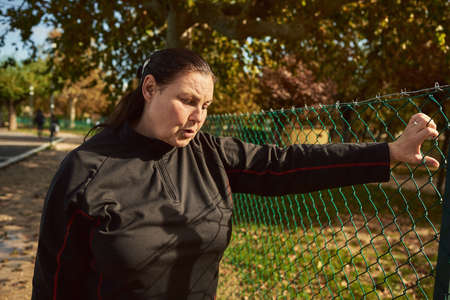 Active senior woman breathing after running outdoors.の写真素材