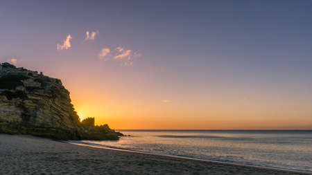 Colorful sky at morning with rock before sunrise at praia da Figueira, Portugalの写真素材