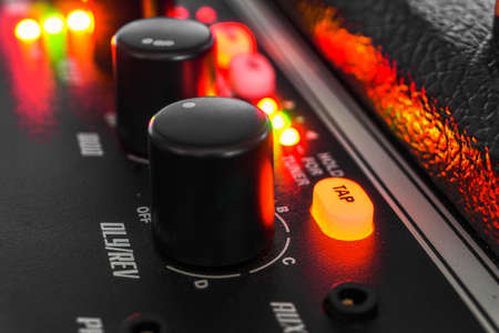 Detail of an amplifier for electric guitar with green and red lights