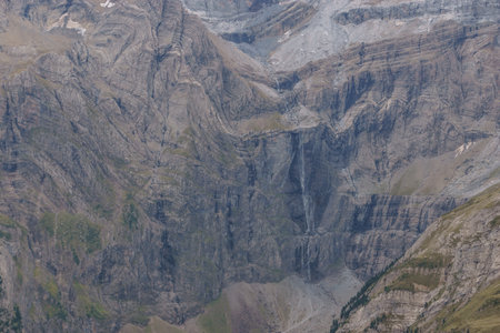 Distant detail view at famous Gavarnie waterfalls in french Pyrenees in extreme terrain with massive rock wall formation, Nouvelle-Aquitaine, Franceの写真素材