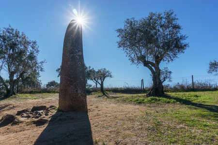 Menhir dos Almendres with sun on the blue sky near Portuguese town Evora, Alentejo, Portugalの写真素材