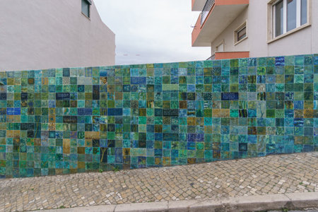 Wall besides street covered with green, blue and turquoise tiles, Lisbon, Portugalの写真素材