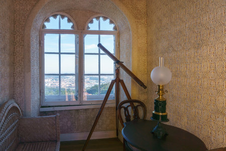 old ancient telescope stands in a room near the windowの写真素材