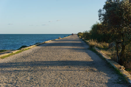 Gravel road at breakwater on the Guadiana River in city Vila Real Santo Antonio, Algarve, Portugal
