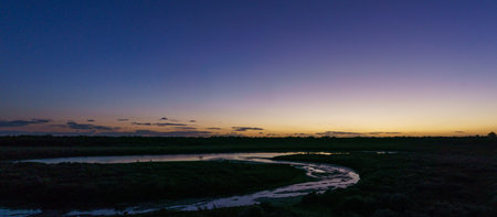 View at small lake on the atlantic coast near Praia da Ponta da Areia beach during evening twilight,...