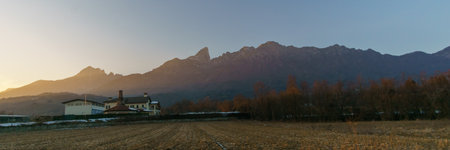 Rural scene of the Po Valley with mountain skyline of the Alps illuminated with golden sunlight...