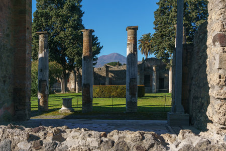 Garden inside ancient luxury house Casa del Fauno in the ruins of Pompei with view through columns at volcano Mount Vesuvius, Pompeii, Campania, Italyの写真素材