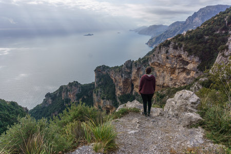 Hiker standing at the cliffs of hiking trail Sentiero degli Dei or Path of the Gods along the Amalfi Coast, Province of Salerno, Campania, Italyの写真素材