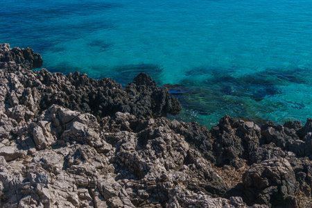 Rocky coast and bay with crystal clear water seen from Mediterranean sea on a sunny day, San Vito Lo Capo, Sicily, Italyの写真素材