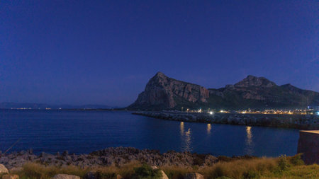 Seascape with beach and view at Monte Monaco during the blue hour at night time, San Vito Lo Capo, Sicily, Italyの写真素材