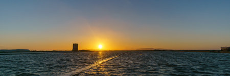 Panoramic view of sunset at tower of Nubia in nature reserve of Saline di Trapani with salt fields, Contrada Nubia, Sicily, Italyの写真素材