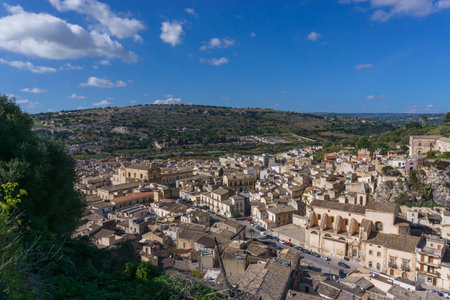 Cityscape of small town in mountains on a sunny spring day, Scicli, Sicily, Italyの写真素材