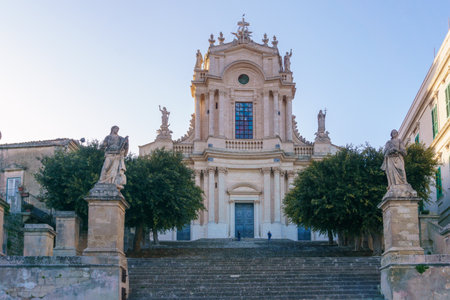 Facade of the beautiful Sicilian baroque church Chiesa di San Giovanni Evangelista on a sunny day, Modica, Sicily, Italyの写真素材