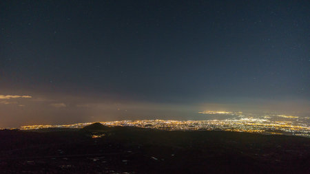 Illuminated city of Catania from Etna at starry night with volcanic landscape during winter time, Catania, Sicily, Italyの写真素材