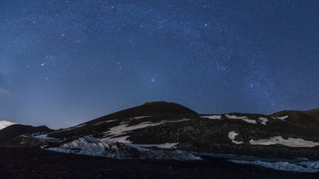 Starscape with Milky Way, Pleiades and Orion constellation over volcanic landscape of Mount Etna during winter time, Catania, Sicily, Italyの写真素材