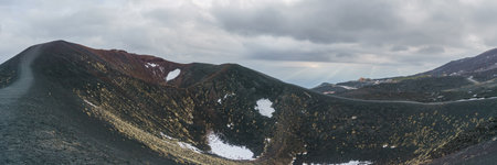 Panoramic view of volcanic landscape of Mount Etna near the Silvester craters on a cloudy winter day, Catania, Sicily, Italyの写真素材