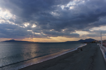 Atmospheric dark sunset in Neapoli with sun rays shining through clouds in the sky, Neapoli, Laconia, Peloponnese, Greeceの写真素材
