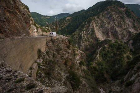 Camper van standing at a cliff with beautiful view at Greek landscape in the mountains of Evrytania with Proussos Monastery, Greece, Central Greeceの写真素材