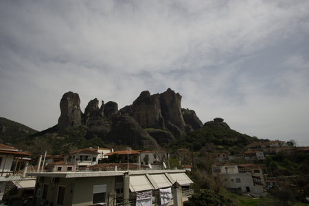 The Meteora rock formation with famous monasteries on top seen from down the city with some houses in front, Kalambaka, Thessaly, Greeceの写真素材