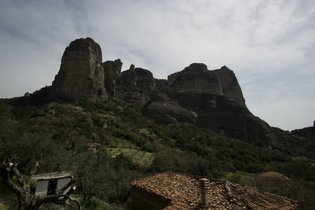 The Meteora rock formation with famous monasteries on top seen from down the city with some houses in front, Kalambaka, Thessaly, Greeceの写真素材