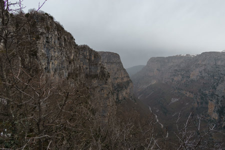 View of the impressive Vikos gorge in the Zagoria region at Pindus Mountains on a foggy winter day with atmospheric mood, Epirus, Greeceの写真素材