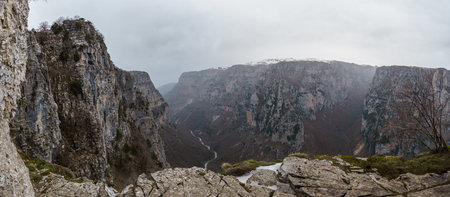 Panoramic view of the impressive Vikos gorge in the Zagoria region at Pindus Mountains on a foggy...