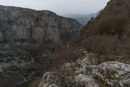 View of the impressive Vikos gorge in the Zagoria region at Pindus Mountains on a foggy winter day...