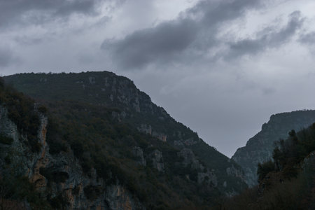 View of the impressive Vikos gorge in the Zagoria region at Pindus Mountains on a dark winter day with atmospheric mood, Epirus, Greeceの写真素材
