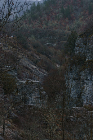 Rocky landscape of the Voidomatis Potamos valley in the Zagoria region at Pindus Mountains on a dark...