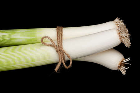 Fresh leeks on a black background.の写真素材