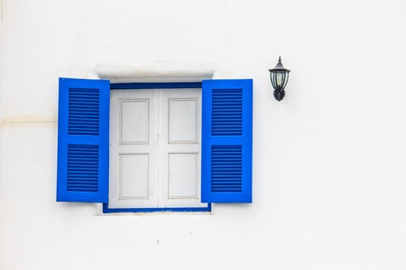 Contrast of blue openned window isolated from white wall.の写真素材