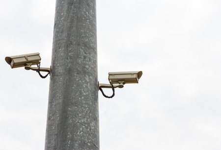 2 CCTV on Post face to opposite side and isolated from sky 