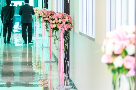Two business man walk away through the path decorated with plastic flower の写真素材