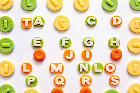 Colorful alphabet letters and shapes arranged on white background.の素材