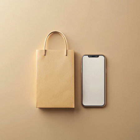 Small paper bag and a smartphone laying side-by-side on a tan surfaceの素材
