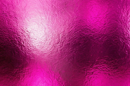 Abstract pink metallic texture with a crumpled, shiny surface and gradient lighting.の素材