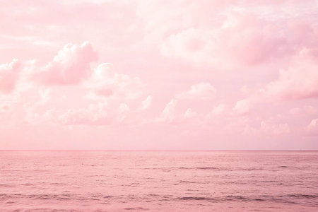 Pink sunset sky over calm ocean; peaceful beach background; idyllic nature sceneの素材