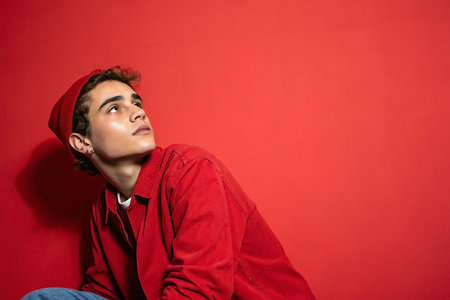 Young man in red outfit, studio shot, looking upward.  Possible stock photoの素材